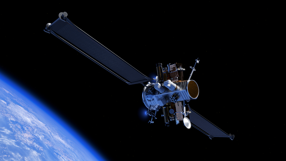 A satellite studded with sensors, instruments, and antennae floats in the black void of orbit above the curved hazy blue surface of the earth, with large, wing-like solar panels extending from either side of its cylindrical body.